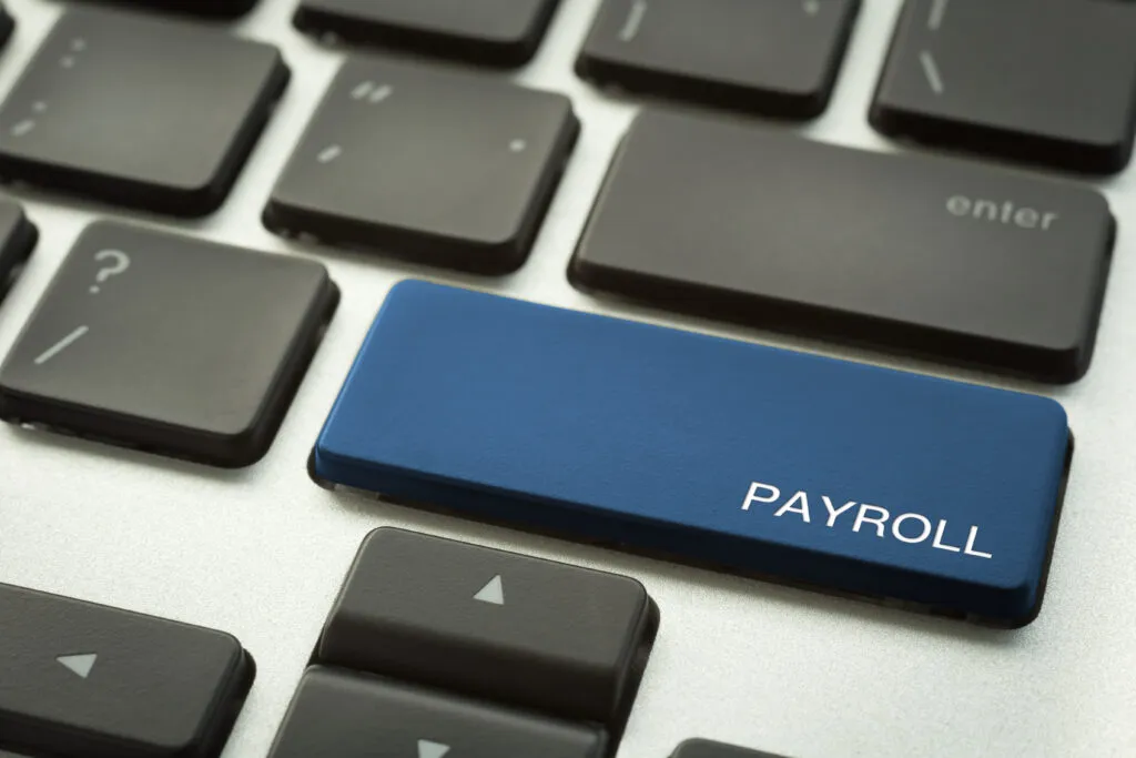 Image ok computer keyboard with a blue button reading 'payroll'